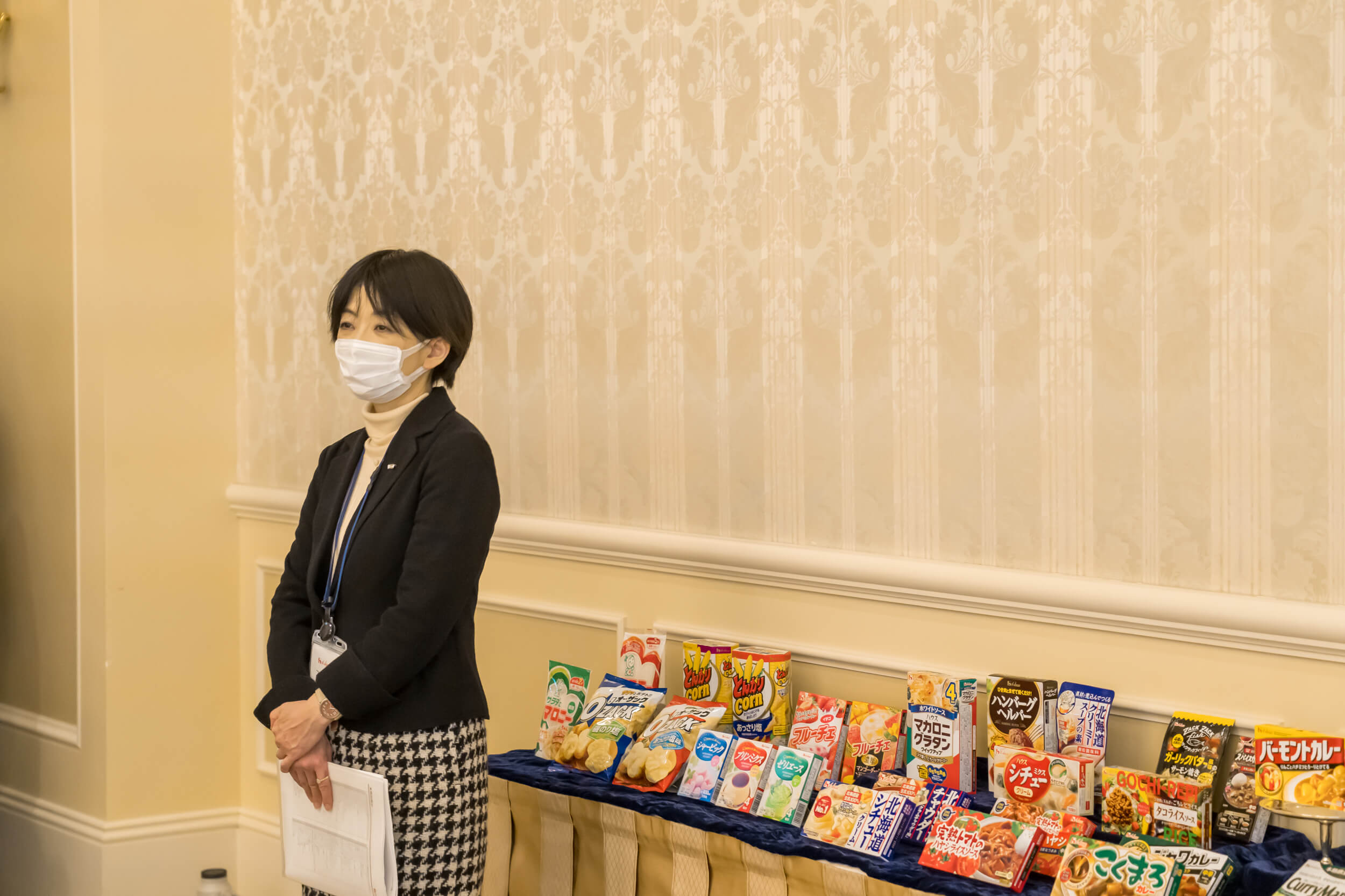 イベントの様子を見守る坂野さん。後ろに並ぶのはハウス食品グループの製品。