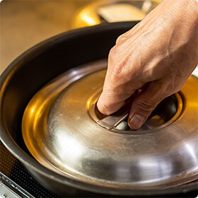 鶏肉を焼くときは、フライパンより一回り小さい蓋で上から押しつけるように焼き付けましょう。